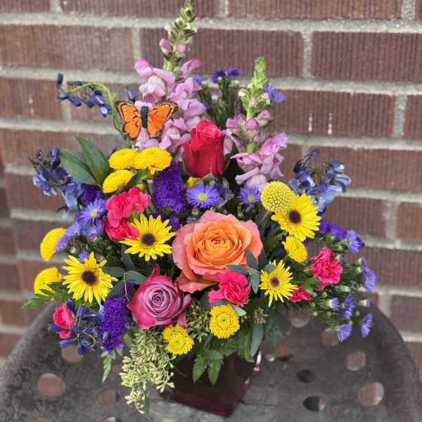 Colorful mixed bouquet with roses, daisies, and snapdragons in a vase