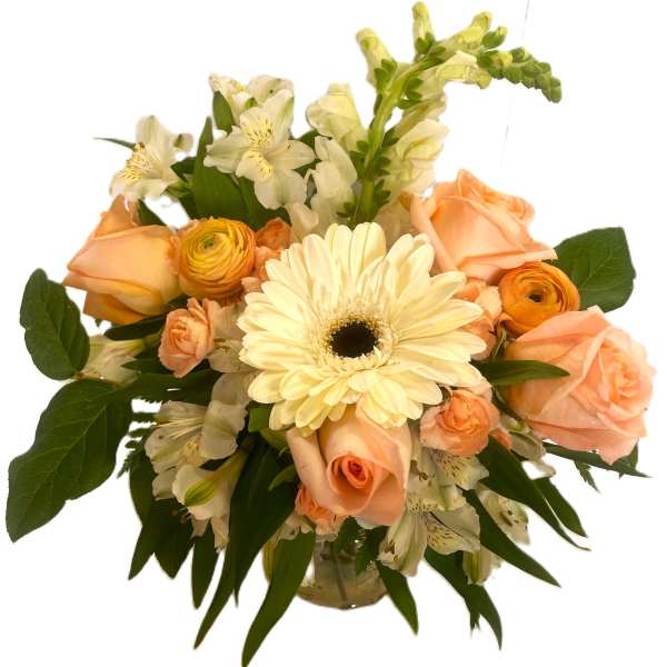 Peach roses and cream gerbera daisies in a glass vase