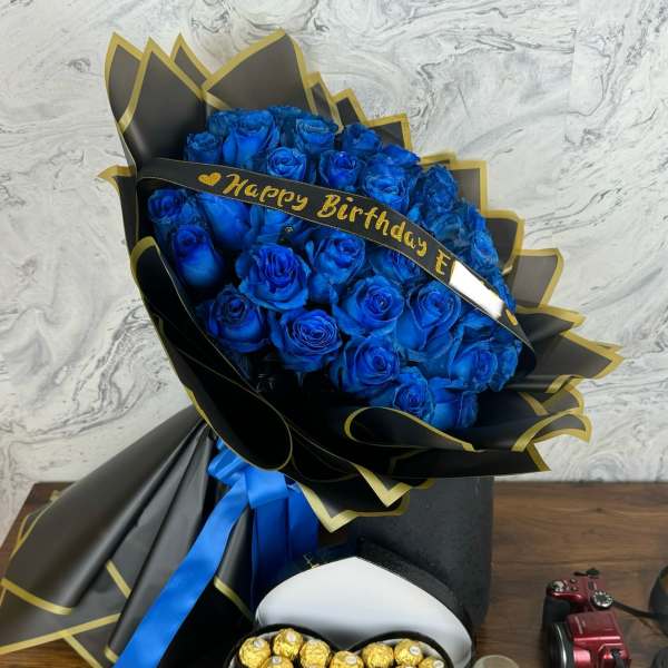 Blue rose bouquet with a birthday ribbon and heart-shaped chocolate box