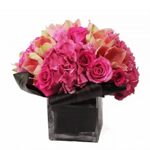 Pink and coral flower arrangement in a black vase