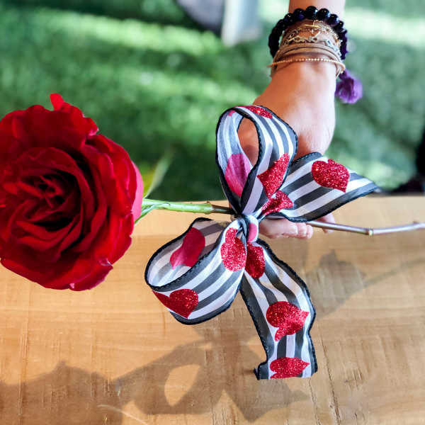 Single red rose with a striped heart ribbon bow