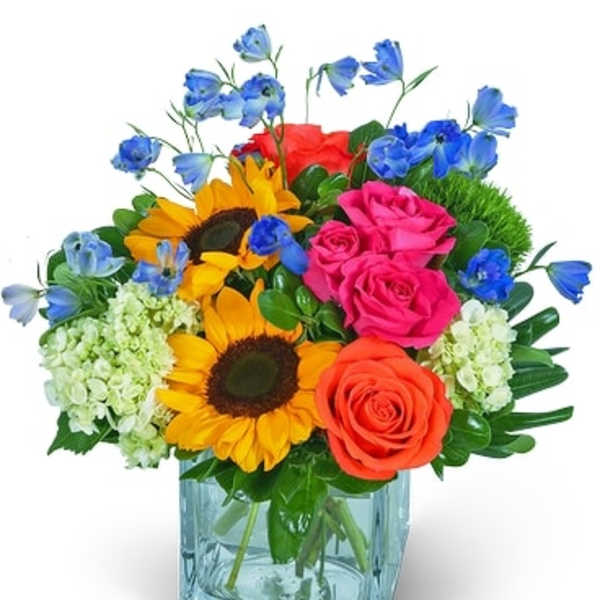 Colorful bouquet of roses, sunflowers, and blue flowers in a glass vase