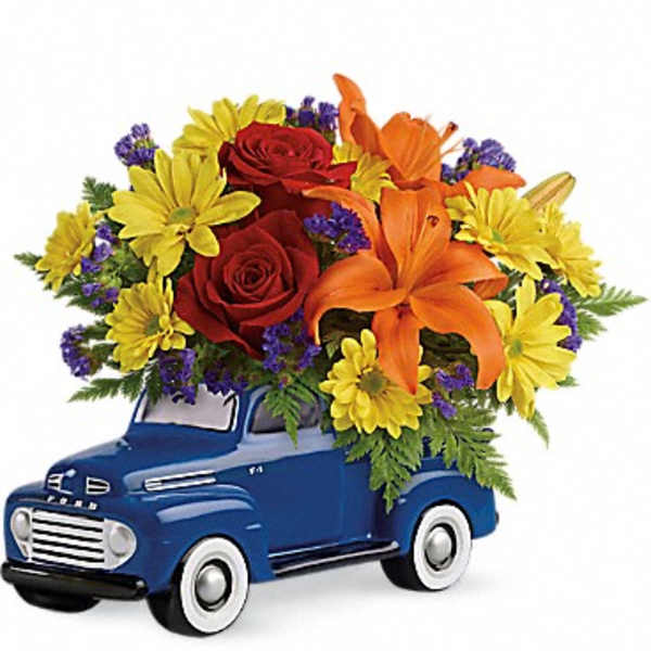 Flower arrangement in a blue vintage truck container
