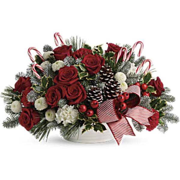Red roses and white flowers in a holiday centerpiece with candy canes