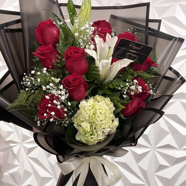 Bouquet of red roses and white lilies with a pale hydrangea bloom