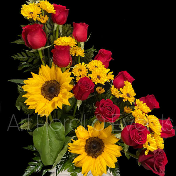 Red roses and yellow sunflowers in a white vase