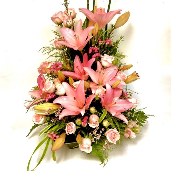 Pink lilies and roses arranged in a tall bouquet
