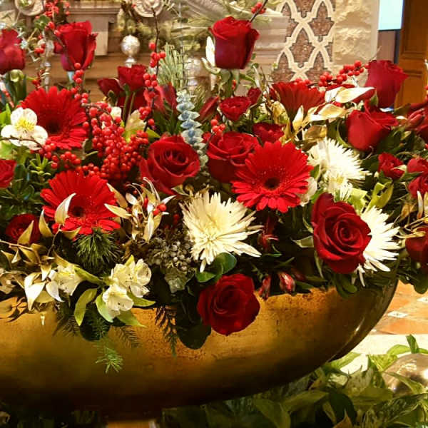 Large arrangement of red roses and white flowers in a gold bowl vase