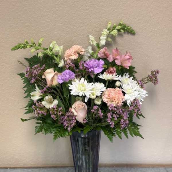 Mixed pastel bouquet in a tall dark vase