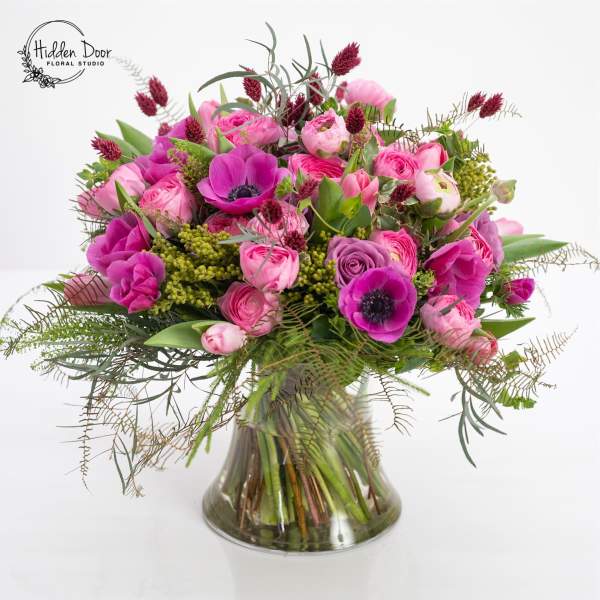 Pink and magenta bouquet in a clear glass vase