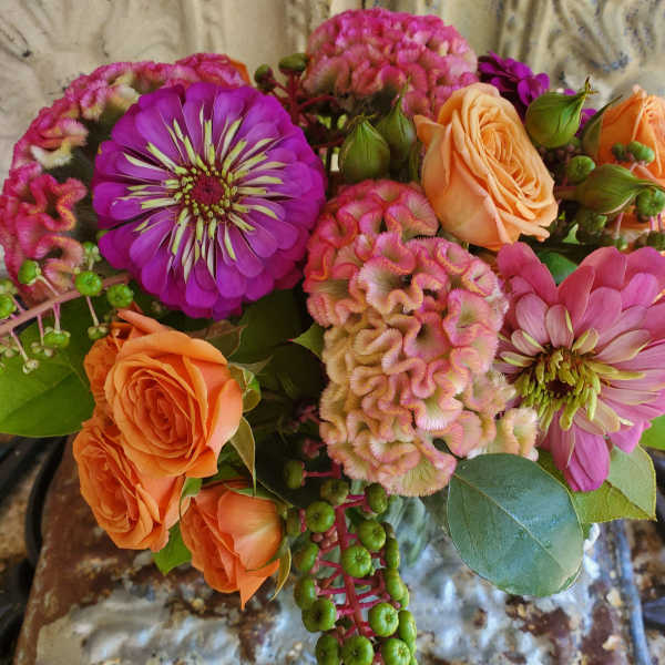 Bouquet of orange roses, pink zinnias, and pink cockscomb