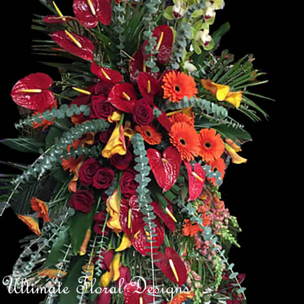 Large tropical floral arrangement with red anthuriums and orange gerbera daisies
