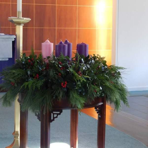 Advent wreath with purple and pink candles on a table
