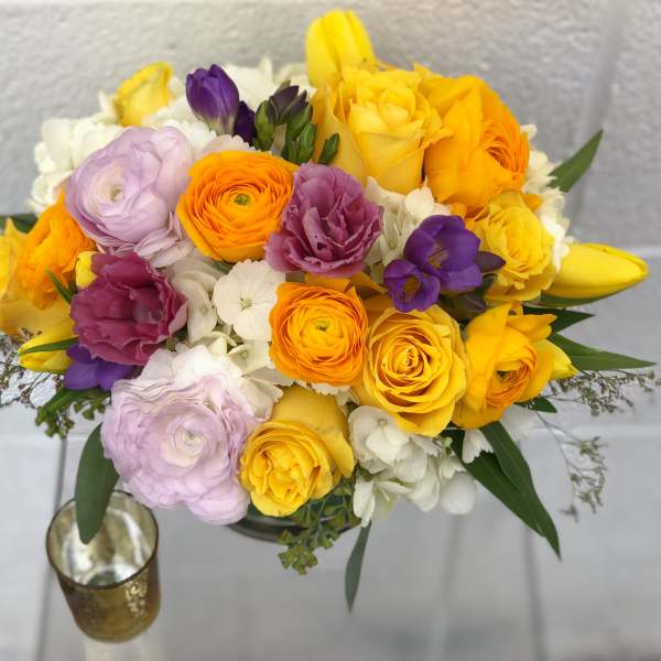 Bouquet of yellow, orange, purple, and white flowers in a vase