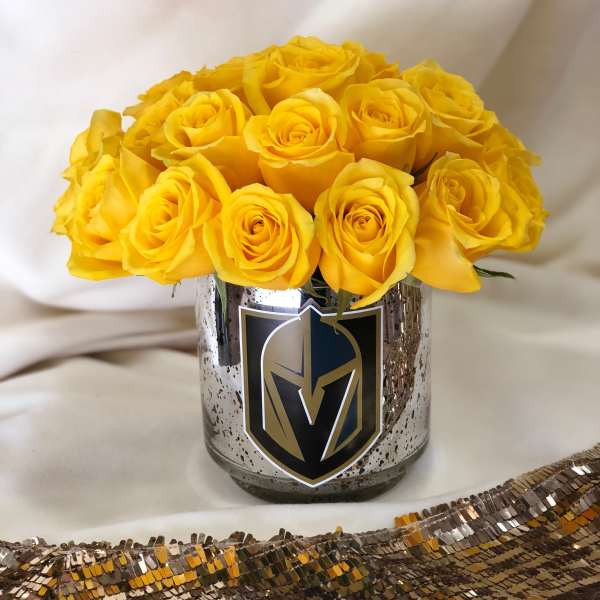 Yellow roses arranged in a metallic vase with a sports logo