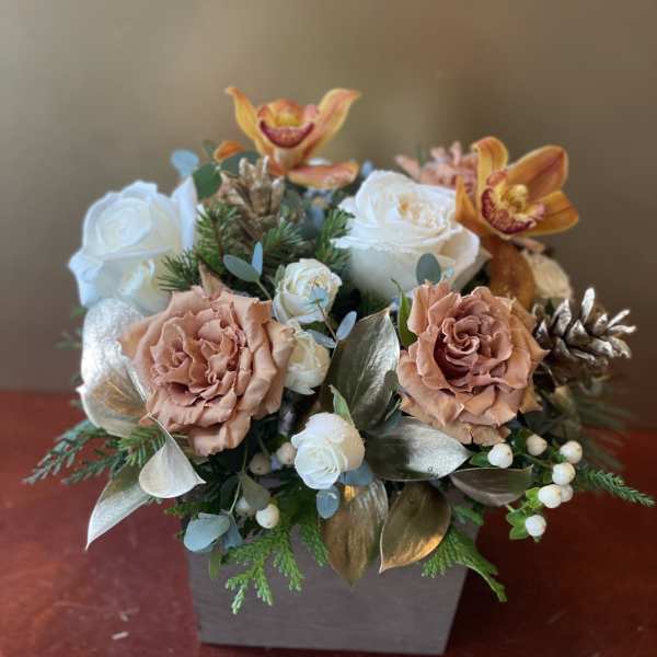 Floral arrangement with peach roses, white roses, and orange orchids in a square vase