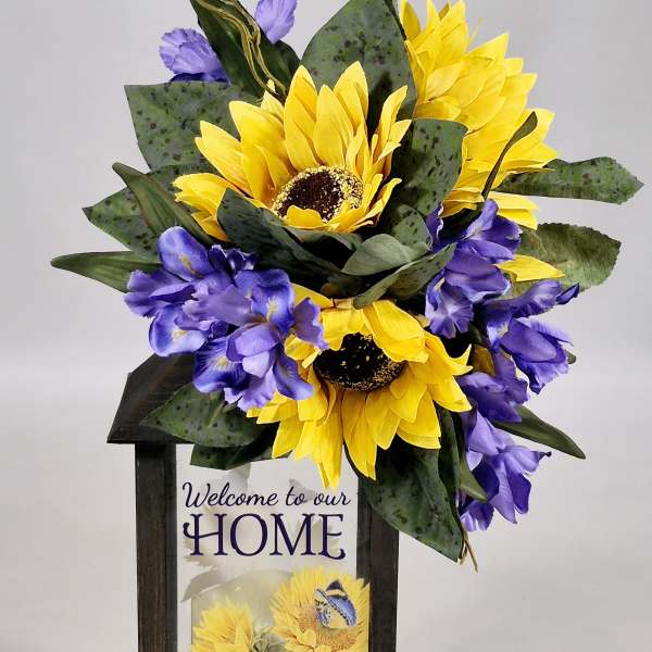 Sunflower arrangement in a wooden lantern with a welcome sign