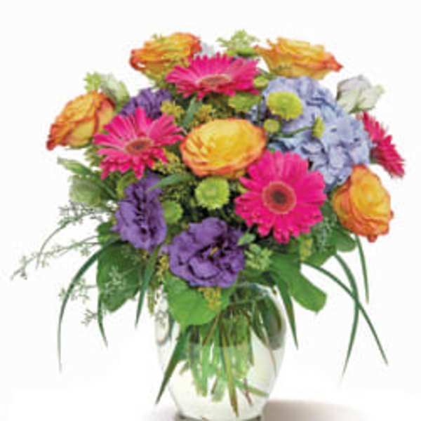 Mixed bouquet of bright flowers in a clear glass vase