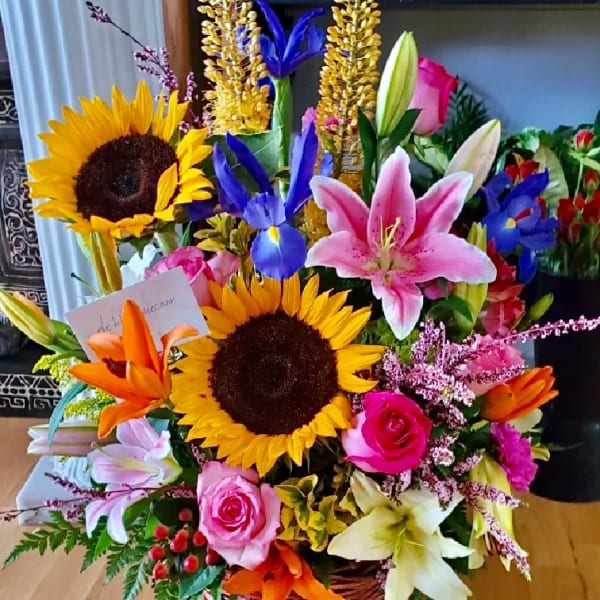 Basket arrangement with sunflowers, lilies, roses, and irises