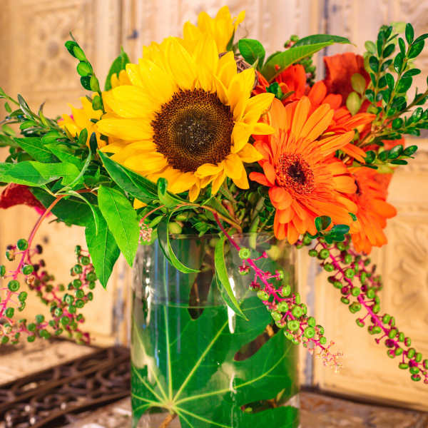 Sunflowers and orange gerbera daisies in a glass vase