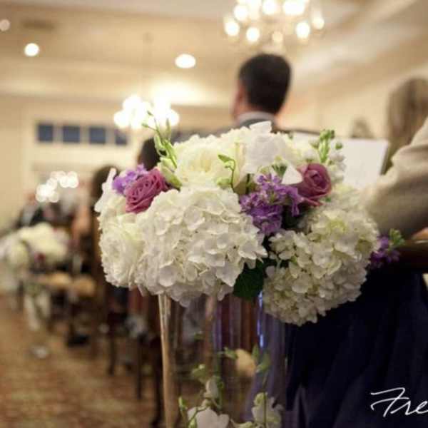 White and purple wedding bouquet in a clear vase