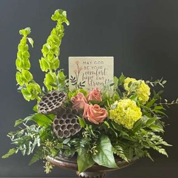 Arrangement of pink roses and yellow flowers with tall green blooms in a vase