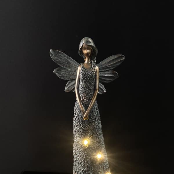 Decorative angel figurine with glowing lights on a dark background