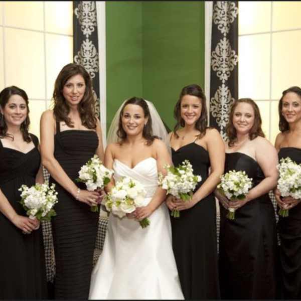 Bride and bridesmaids holding white bouquets in black dresses