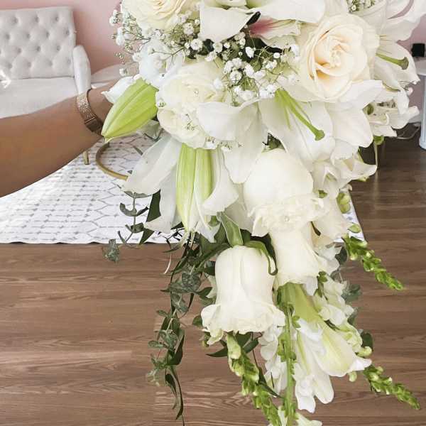 White bridal bouquet with lilies, roses, and trailing flowers