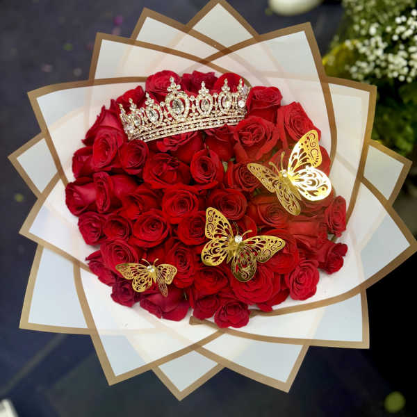 Bouquet of red roses with a jeweled crown and gold butterfly decorations