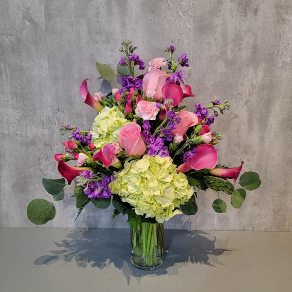 Pink and purple floral arrangement in a clear glass vase