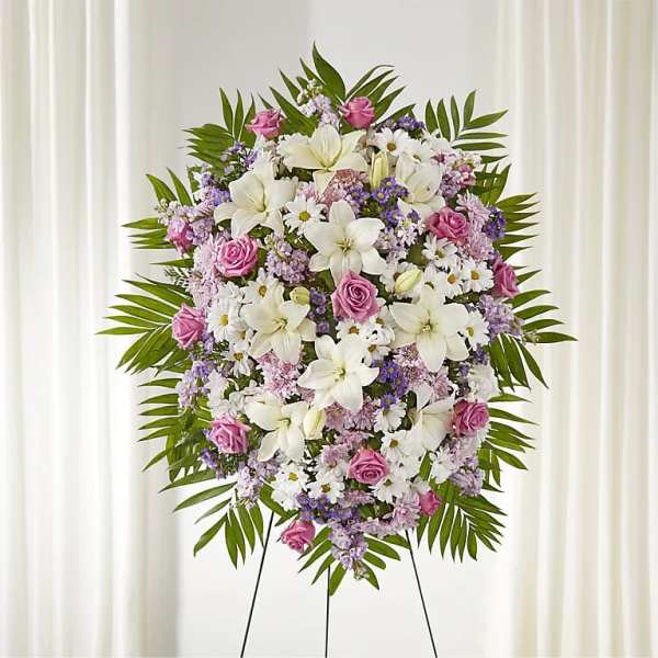 Standing floral wreath with white lilies, pink roses, and purple accents
