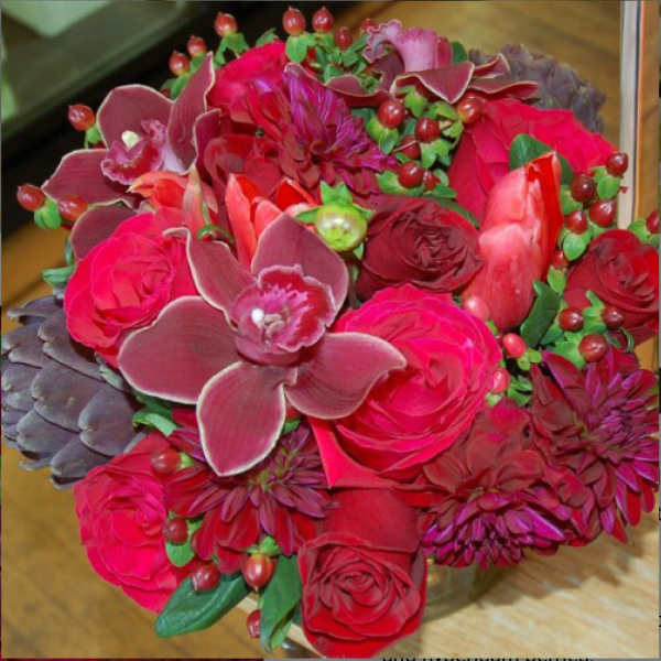 Bouquet of red and pink flowers with orchids in a vase