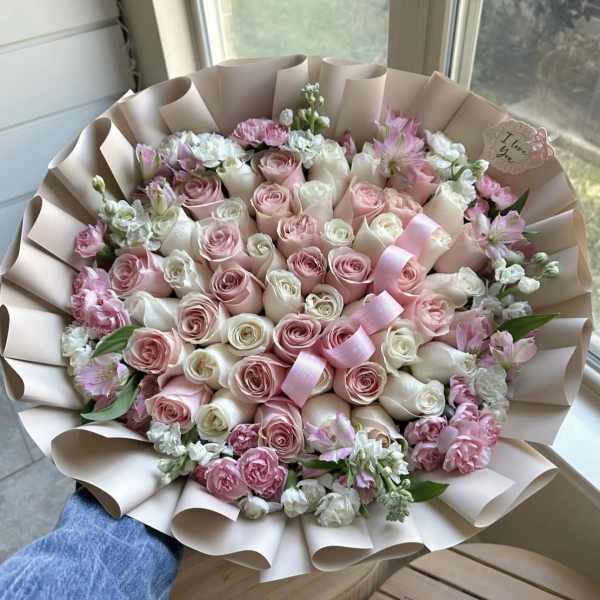 Large bouquet of pink and white roses with ribbon in blush wrapping