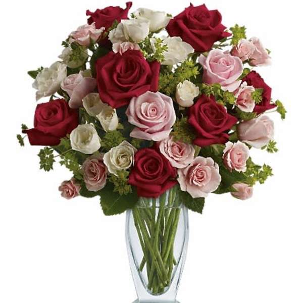 Bouquet of red, pink, and white roses in a clear glass vase