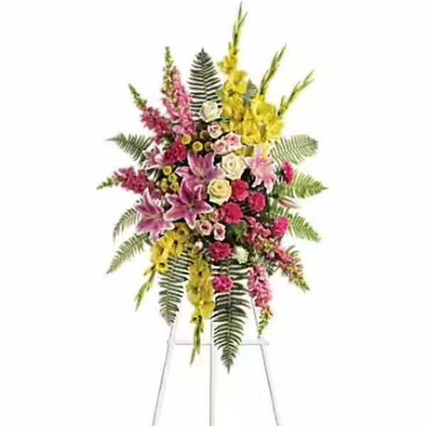 Tall standing floral spray with pink, yellow, and white flowers on a metal easel