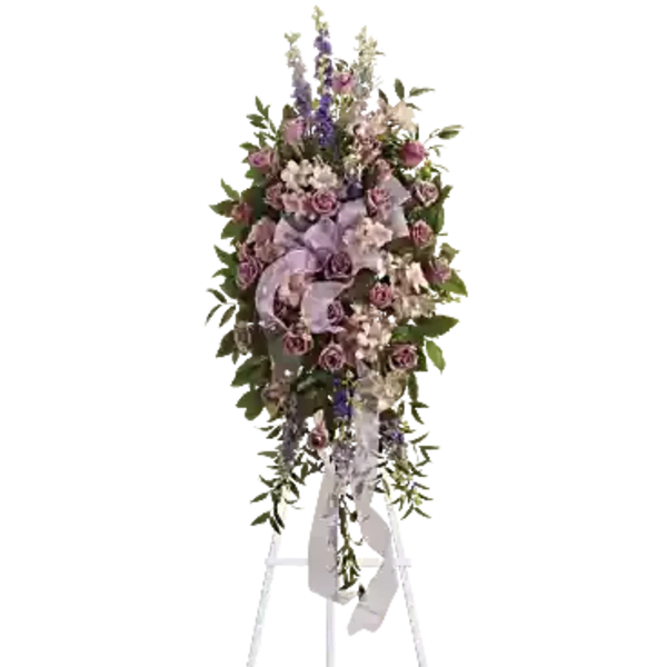 Tall floral standing spray with pink and lavender flowers on a white easel