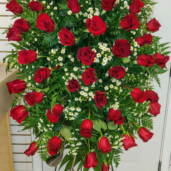 Large standing spray of red roses and white daisies on an easel