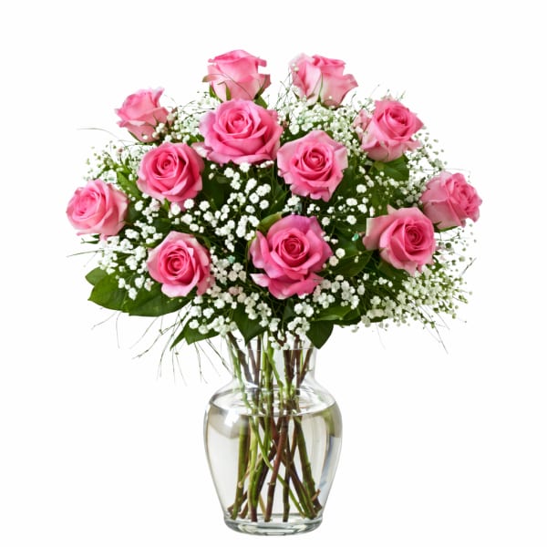 Pink roses arranged in a clear glass vase with white filler flowers