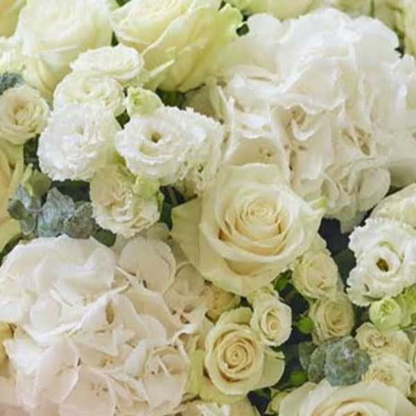 White roses and lisianthus arranged in a dense bouquet
