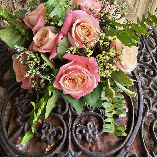 Pink and peach rose bouquet with fern and small white filler flowers