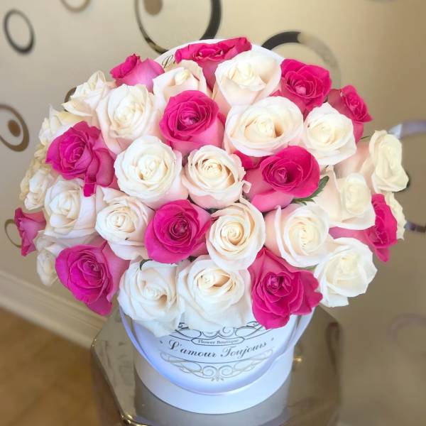 Bouquet of pink and white roses in a white hat box
