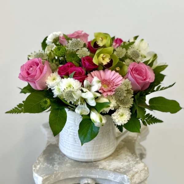 Pink and white mixed flower arrangement in a white vase