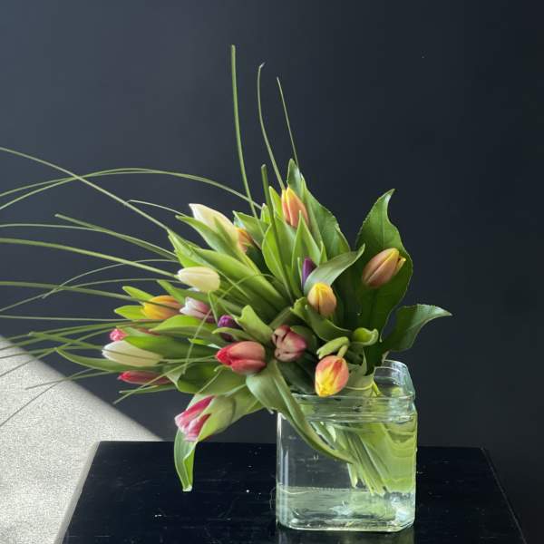 Bouquet of multicolored tulips in a clear glass vase