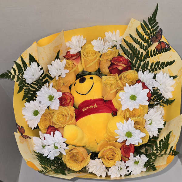 Bouquet with a Winnie the Pooh plush surrounded by yellow roses and white daisies