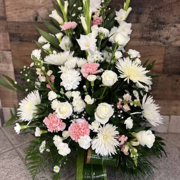 Tall white and pink floral arrangement with roses, carnations, and spider mums