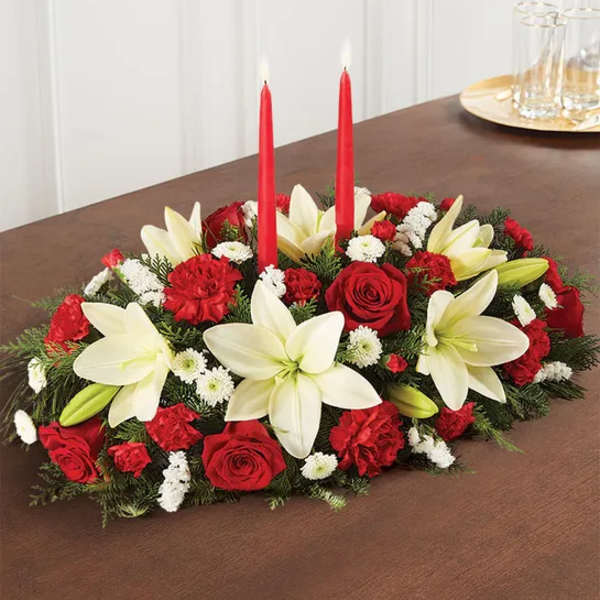 Red and white floral centerpiece with two red candles on a table