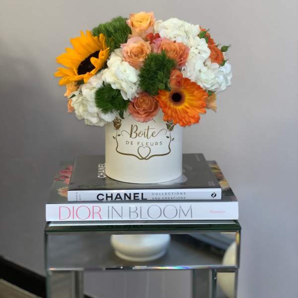 Bouquet of orange and white flowers in a white hat box