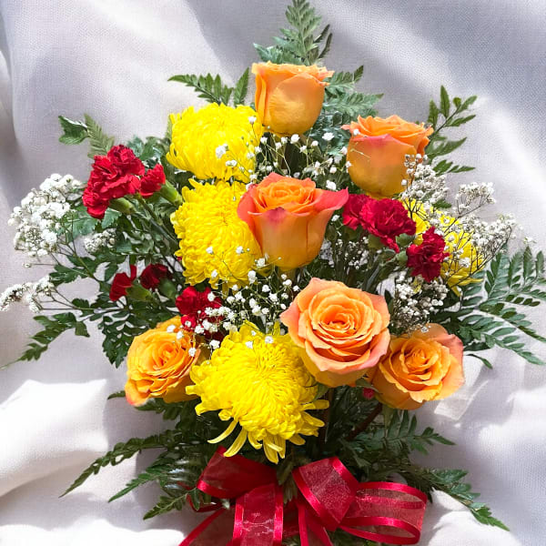 Bouquet of orange roses, yellow chrysanthemums, and red carnations with a red ribbon