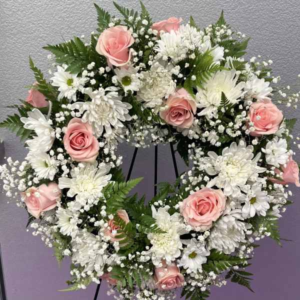 Pink roses and white daisies arranged in a circular wreath